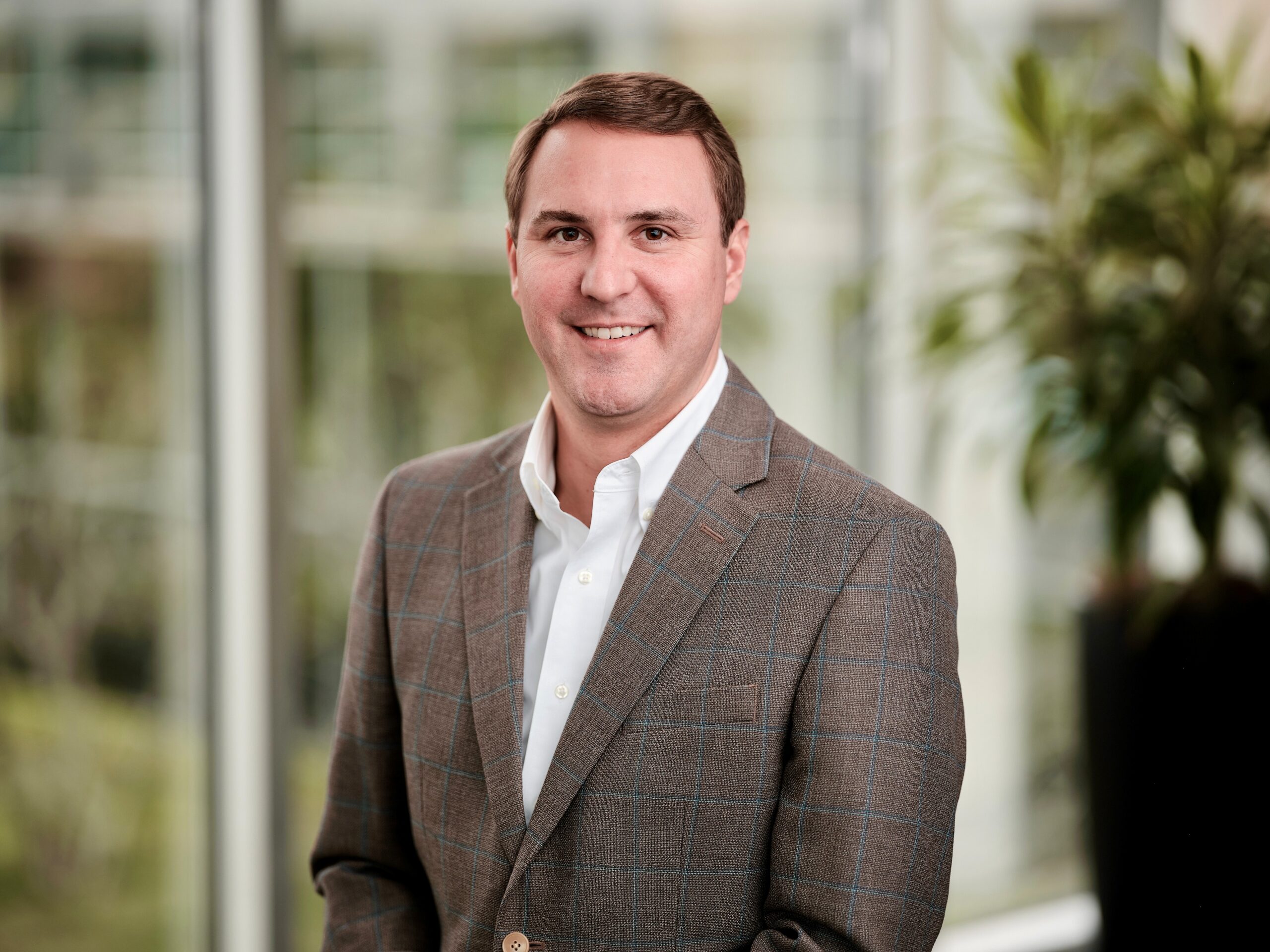 Head shot of Drew Davenport. Man in brown suit.