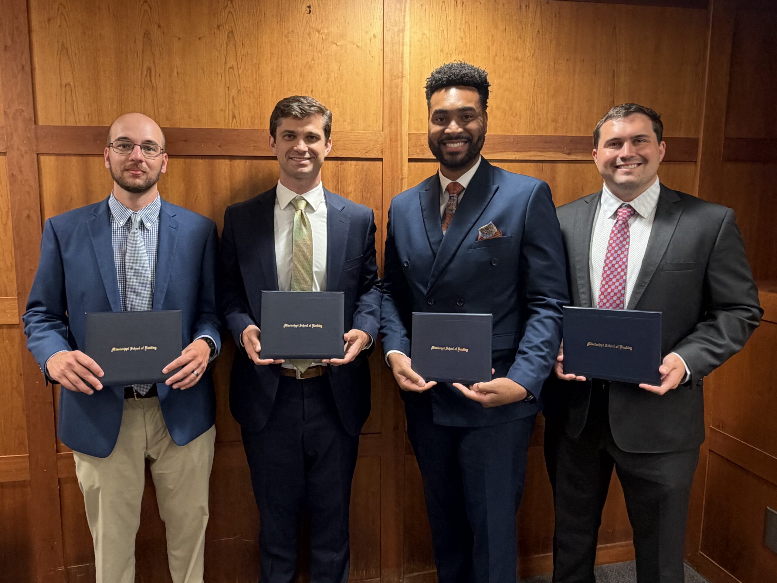 Image of four male Guaranty Bank employees, school of banking graduates.